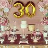 دکوراسیون تولد سی سالگی شامل دیزاین میز کیک و شیرینی، بادکنک های هلیومی و گلهای کاغذی
