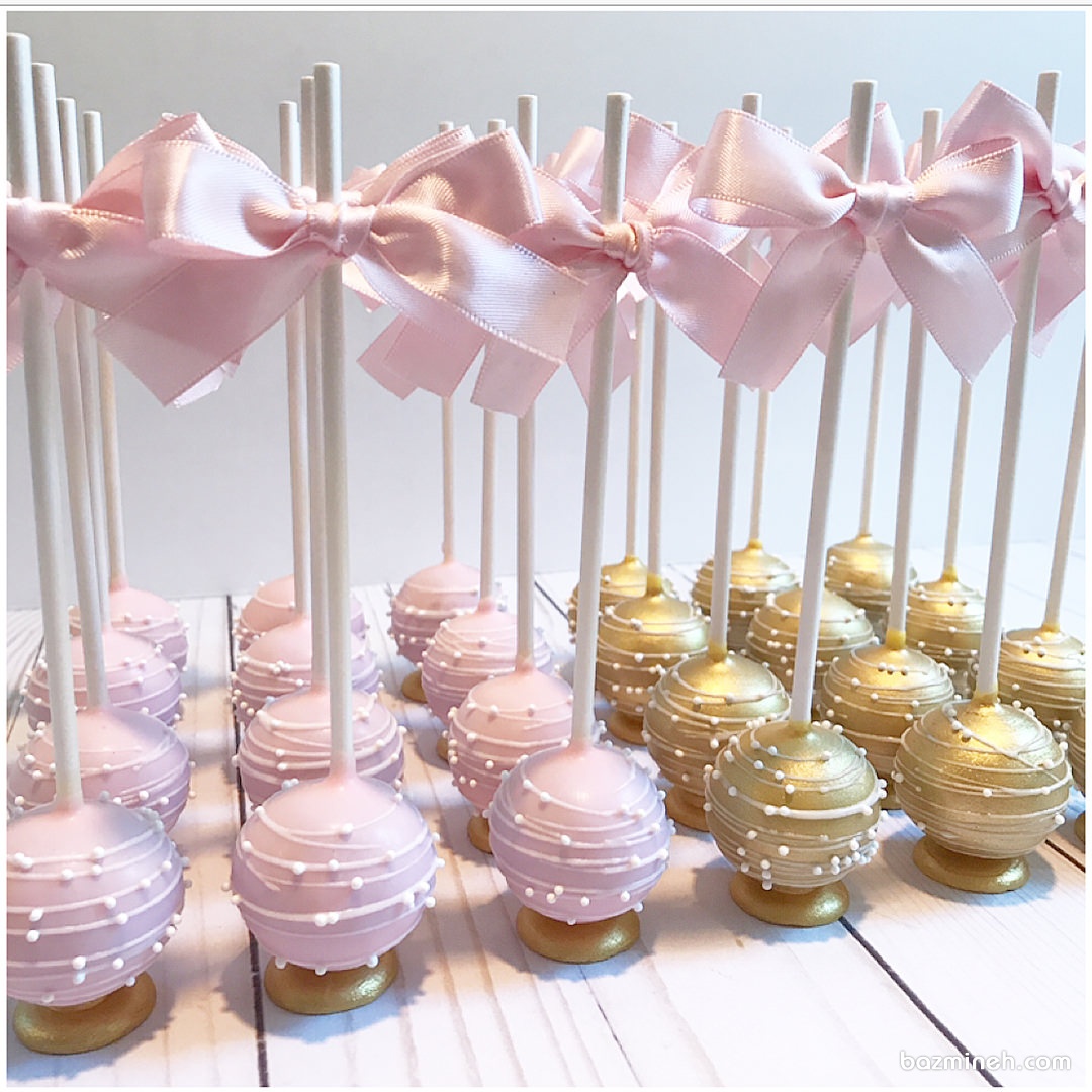 پاپ کیک های چوبی صورتی و طلایی پاپیون دار ایده ای زیبا برای جشن تولد دختر خانم ها