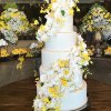 کیک چند طبقه جشن نامزدی و تزیین زیبای آن با گل های ارکیده طبیعی سفید و زرد