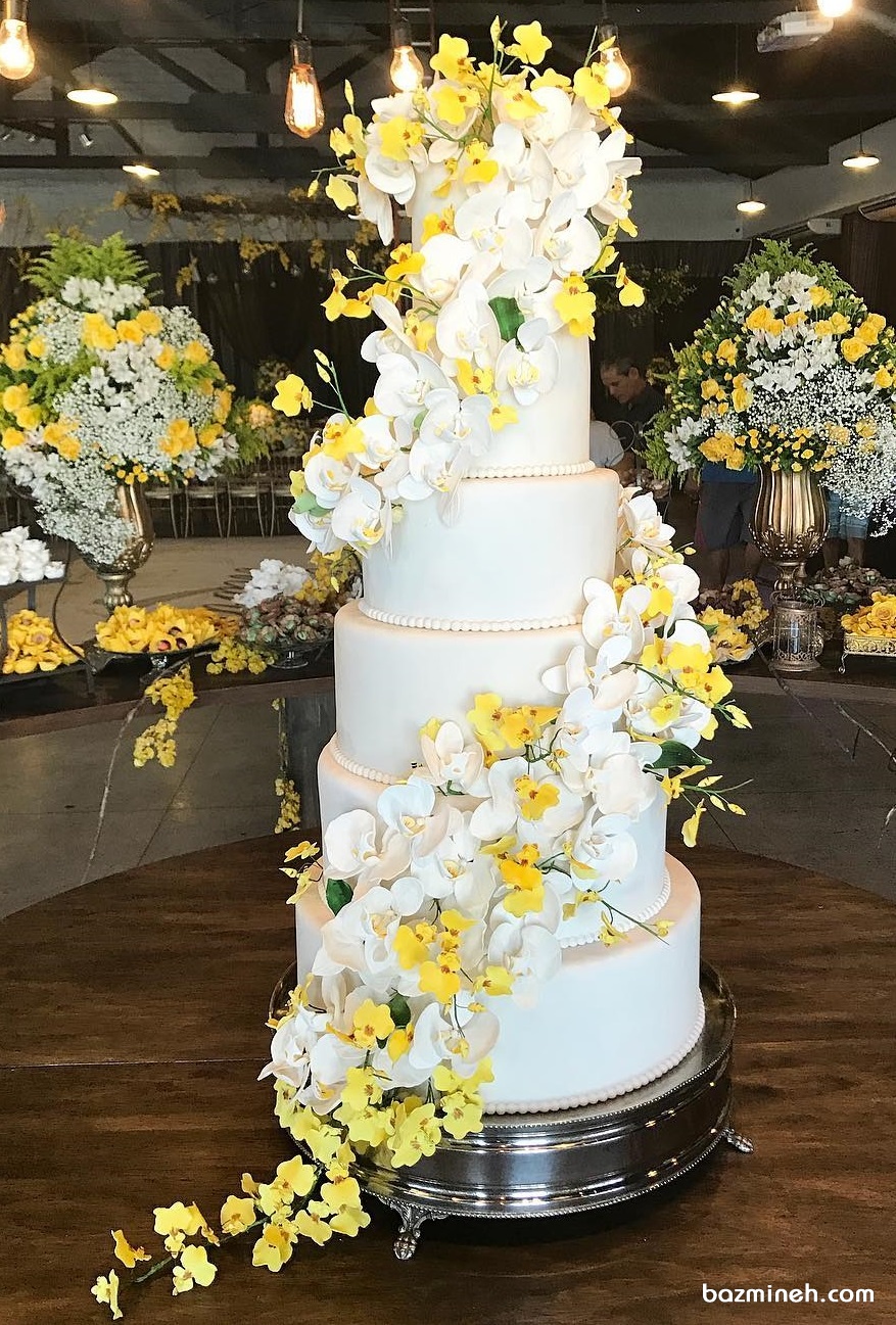کیک چند طبقه جشن نامزدی و تزیین زیبای آن با گل های ارکیده طبیعی سفید و زرد