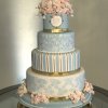 کیک چند طبقه کلاسیک جشن نامزدی یا عروسی تزیین شده با گل های سفید صورتی و طرح های طلایی
