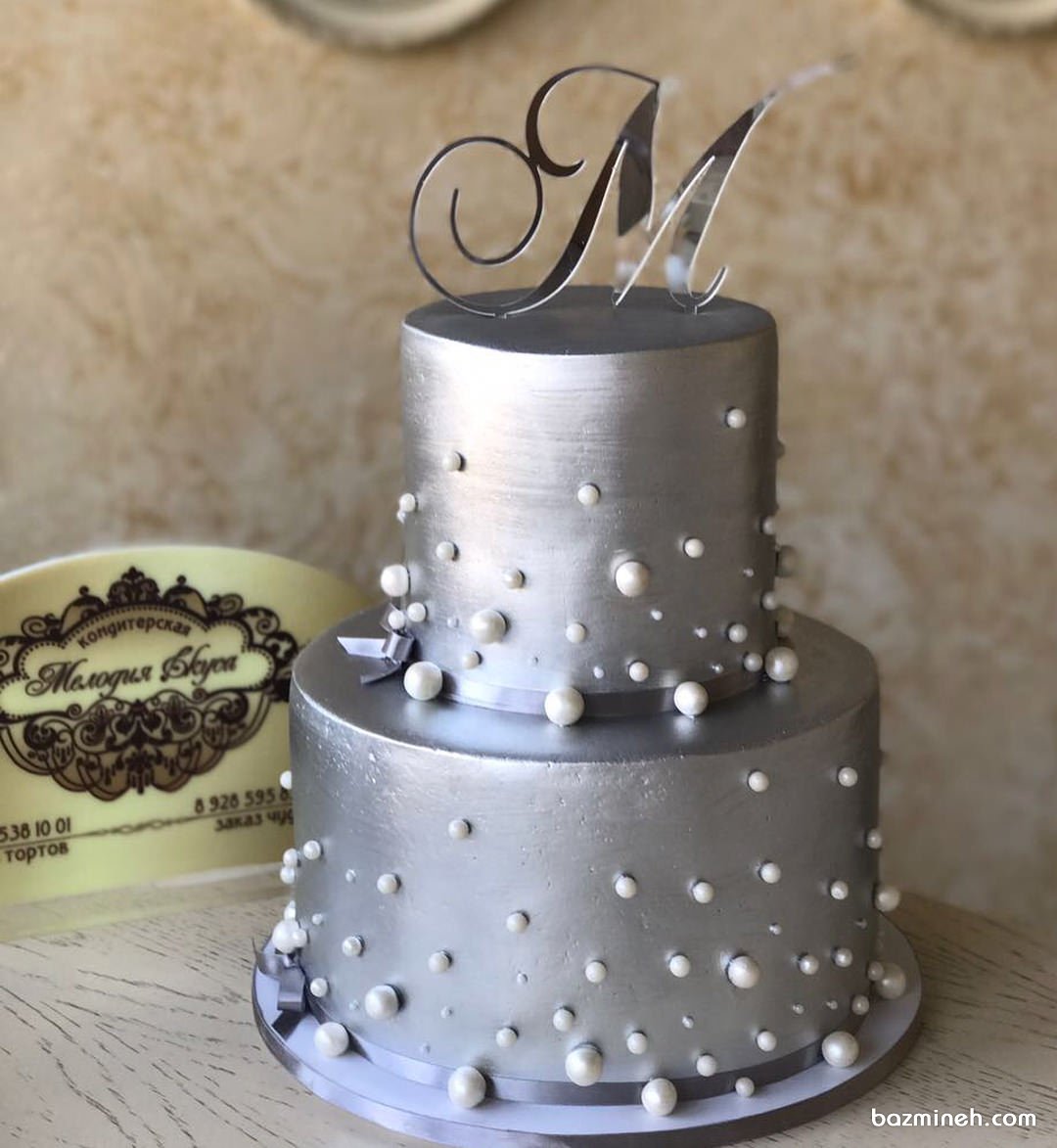 کیک دو طبقه جشن تولد با تم نقره ای تزیین شده با مرواریدهای صدفی