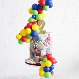 کیک جشن تولد دو سالگی کودک تزیین شده با بادکنک های کوچولوی رنگی