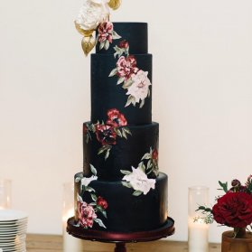 کیک چند طبقه خاص با تم مشکی و گل های درشت سفید قرمز مناسب برای جشن سالگرد ازدواج