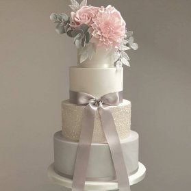 کیک چند طبقه جشن نامزدی، عروسی یا سالگرد ازدواج تزیین شده با گل های صورتی و پاپیون