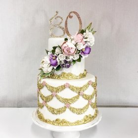 کیک لوکس جشن تولد بزرگسالان تزیین شده با طرح های طلایی و گل های مصنوعی