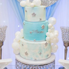 کیک چند طبقه جشن بیبی شاور پسرانه با تم ماه و ستاره تزیین شده با بادکنک های کوچولوی بامزه