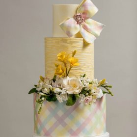 کیک چند طبقه جشن نامزدی یا سالگرد ازدواج با تم زرد تزیین شده با گل و پاپیون