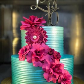کیک دو طبقه جشن تولد تزیین شده با گل های کاغذی سرخابی 