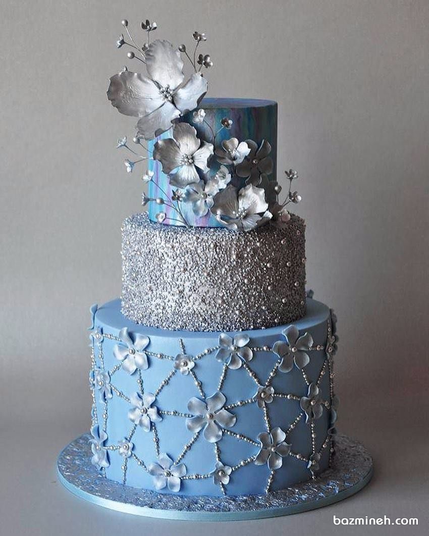 کیک چند طبقه خاص جشن نامزدی یا سالگرد ازدواج با تم آبی نقره ای تزیین شده با گل های درشت نقره ای