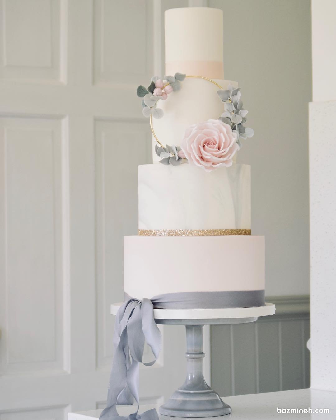 کیک چند طبقه فانتزی و رویایی جشن نامزدی یا عروسی با تم سفید طوسی صورتی تزیین شده با گل و ربان