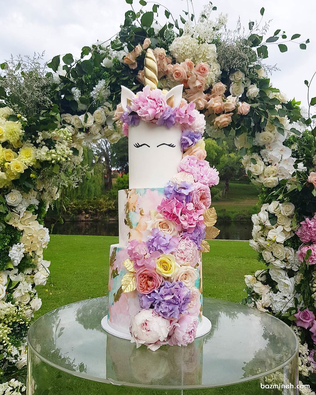 کیک چند طبقه زیبای جشن تولد دخترانه با تم اسب تک شاخ (Unicorn) تزیین شده با گل های طبیعی