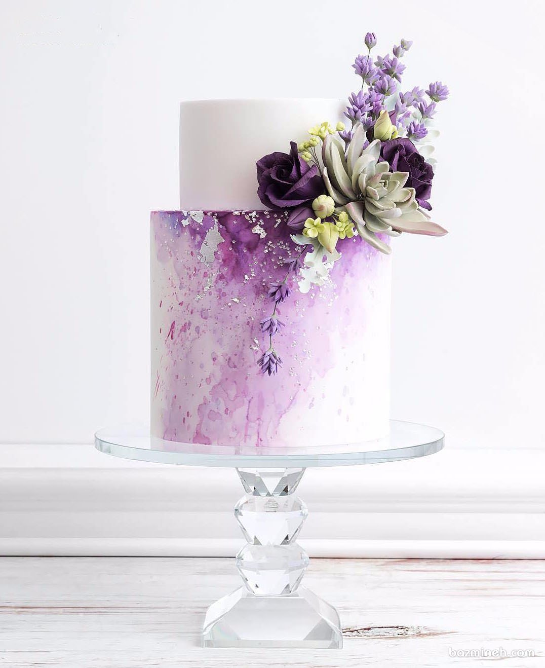 کیک زیبای جشن تولد یا سالگرد ازدواج تزیین شده با گل های طبیعی با تم سفید بنفش