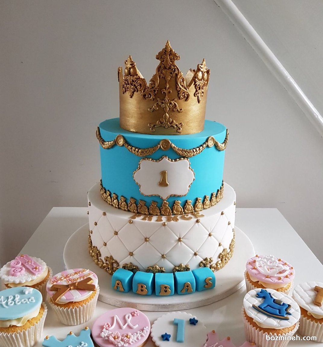 کیک دو طبقه و کاپ کیک های جشن تولد پسرانه با تم پادشاه سفید آبی