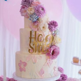 کیک چند طبقه زیبای جشن بیبی شاور یا تعیین جنسیت با تم سفید یاسی تزیین شده با گل های طبیعی 