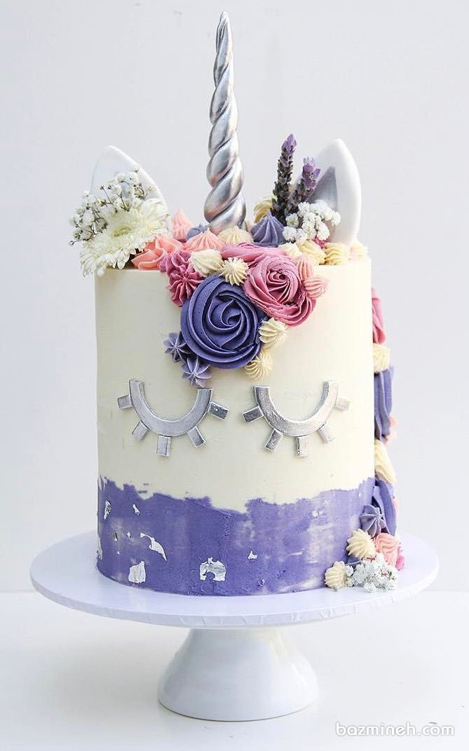 کیک فانتزی جشن تولد دخترانه با تم اسب تک شاخ (یونیکورن) سفید بنفش تزیین شده با گل های طبیعی