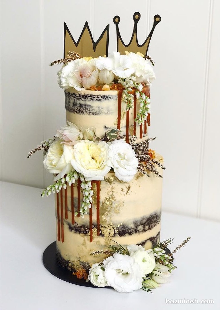 کیک دو طبقه جشن سالگرد ازدوج تزیین شده با گل های طبیعی با تم پادشاه و ملکه