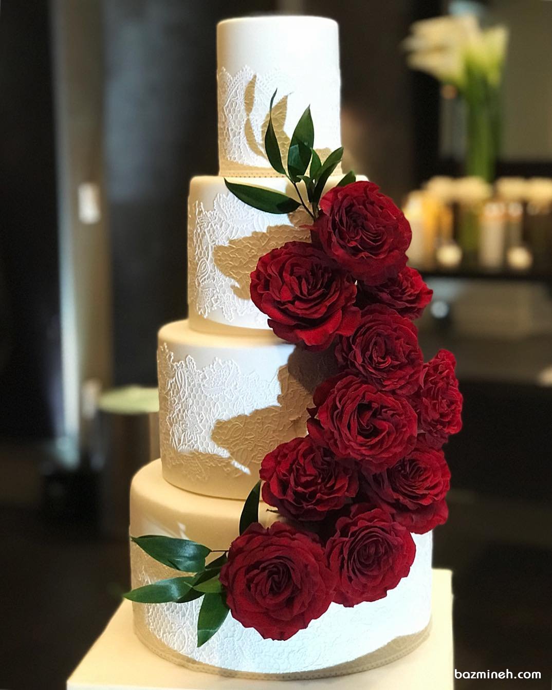 کیک چند طبقه ساده و شیک جشن نامزدی یا عروسی تزیین شده با گل های رز قرمز و طرح تور