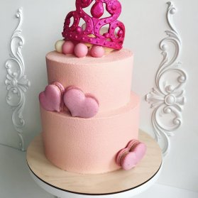 کیک دو طبقه جشن تولد دخترونه با تم ملکه صورتی تزیین شده با ماکارون های قلبی