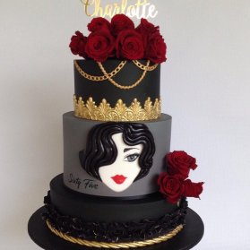 کیک سه طبقه زیبا و منحصر به فرد جشن تولد دخترونه با تم مشکی طلایی تزیین شده با گل های رز قرمز طبیعی