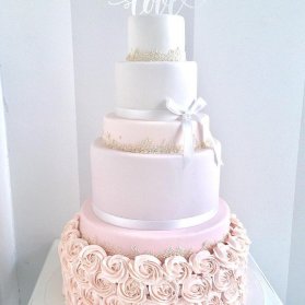 کیک چند طبقه رمانتیک جشن نامزدی یا سالگرد ازدواج با تم سفید صورتی تزیین شده با گل های رز خامه ای