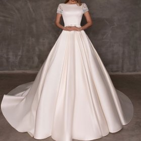 لباس عروس ساده و شیک دنباله دار با یقه گرد و آستین کوتاه گیپوری مدلی زیبا برای عروس خانم‌های ساده پسند