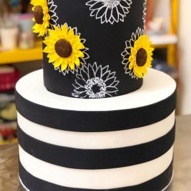 کیک دو طبقه فوندانت جشن تولد بزرگسال یا سالگرد ازدواج با تم سفید مشکی و گلهای آفتابگردون 