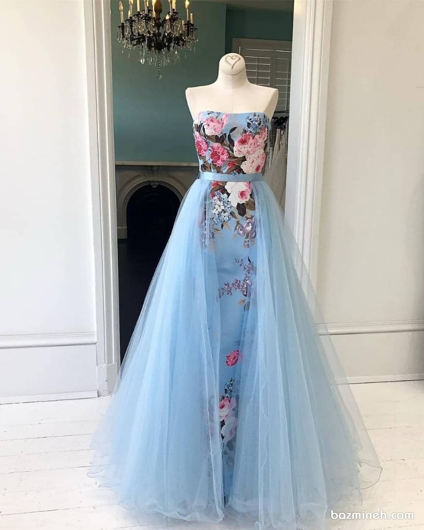 لباس مجلسی یقه دکلته و دامن پفی بلند و پارچه گلدار و تور آبی رنگ پیشنهادی زیبا برای نوعروس‌ها در مجالس 