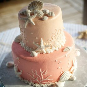 کیک دو طبقه جشن تولد بزرگسال با تم صدف و ستاره دریایی
رنگ صورتی این کیک، آن را برای تولدهای بزرگسال و دخترانه بسیار متناسب نموده است. تم دریایی و تزئینات صدف و المان های اقیانوس ایده بسیار جذابی برای تزئین کیک فوندانتی است. 